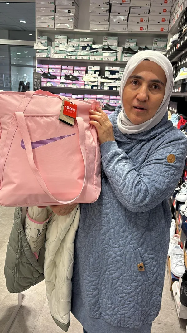 Eine Frau mit einer rosafarbenen Tasche in einem Geschäft